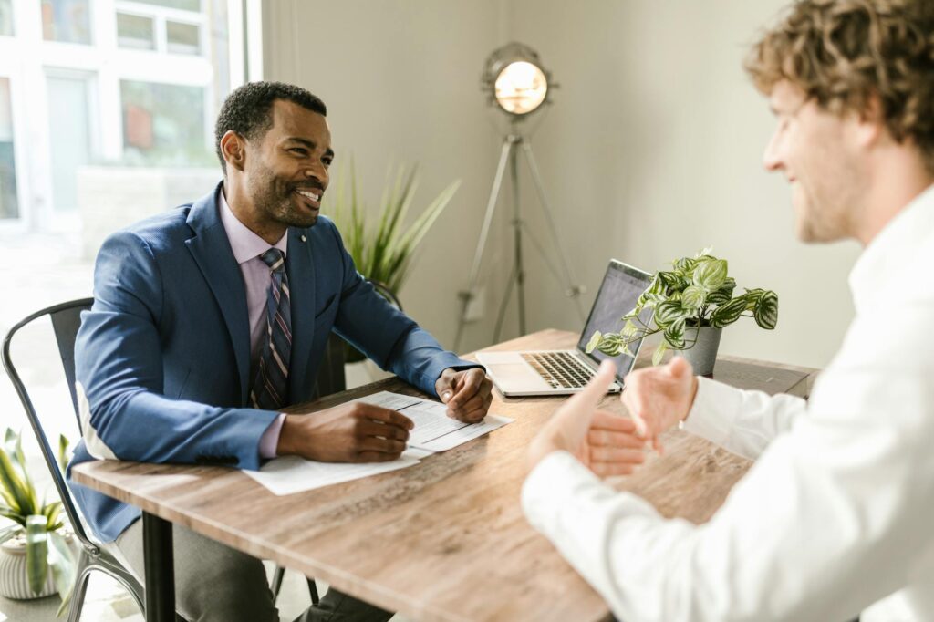 An accountant pointing to a financial document while explaining revenue recognition to a concerned founder.
