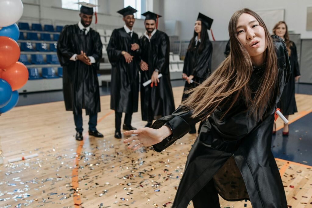 A happy student smiling and stretching at their desk, relieved after completing a difficult online test.