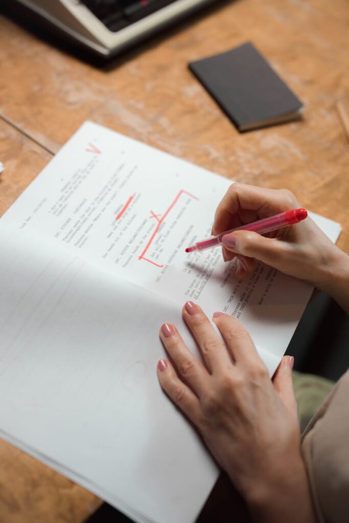 A detailed shot of a person's hands diligently writing mathematical formulas in a spiral notebook.