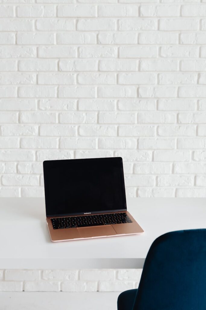 A well-organized home office desk with a computer, notepad, and plant.