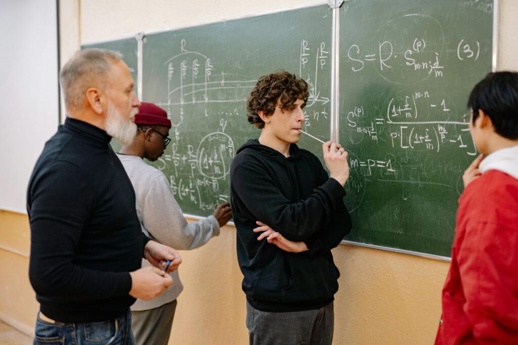 A student viewed from behind, sitting in a lecture hall and paying close attention to the speaker.