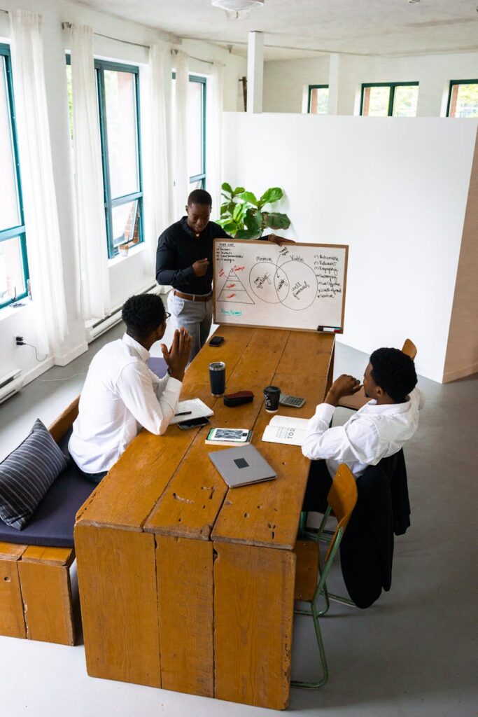 A diverse group of colleagues gathered around a table, actively discussing a document with charts and figures.