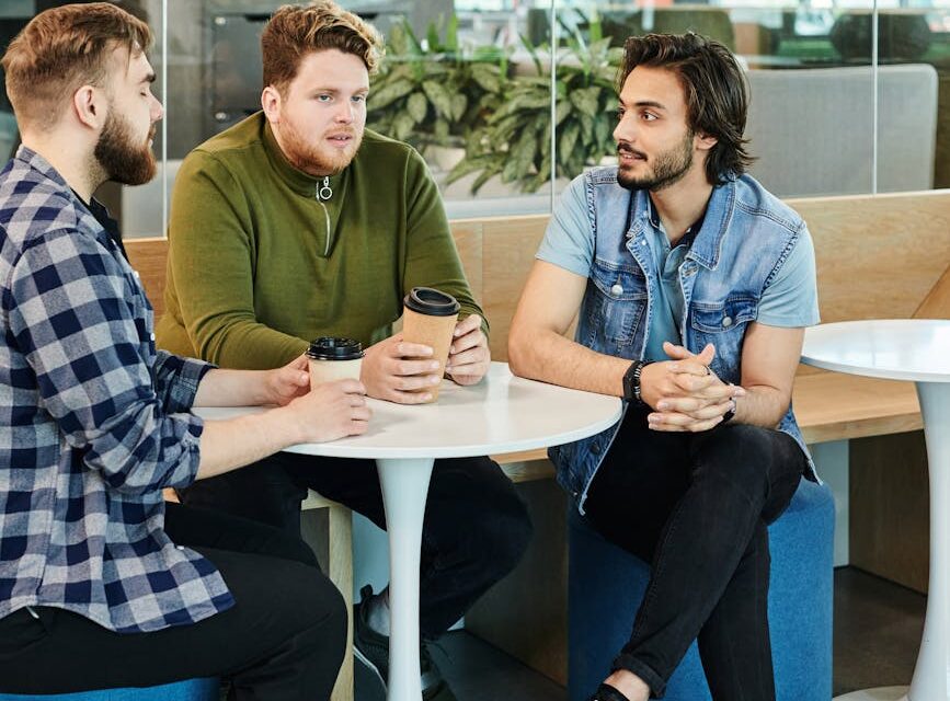 A diverse sales team collaborating around a conference table in a bright, modern office.