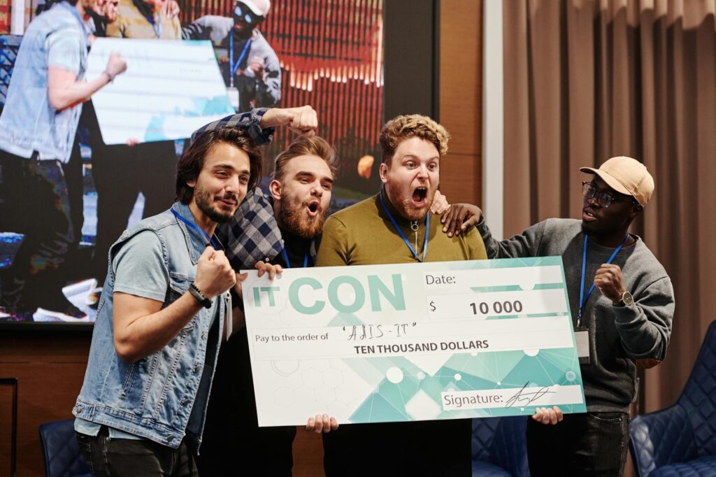 A group of happy sales professionals giving high-fives in an office setting to celebrate success.