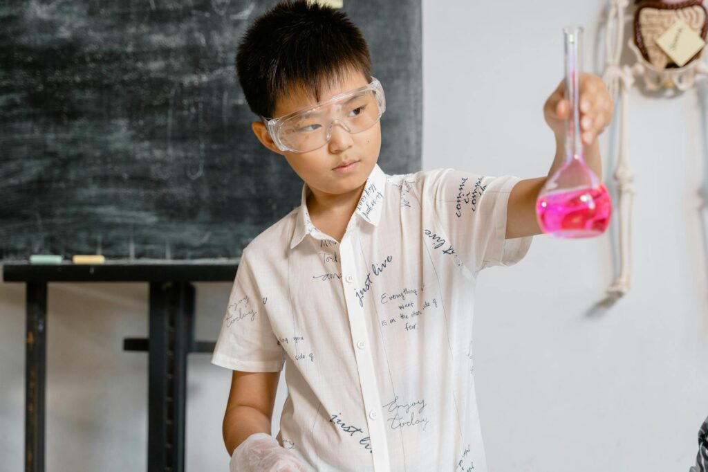 A confident student stands at the front of a classroom, gesturing towards a presentation on a whiteboard.