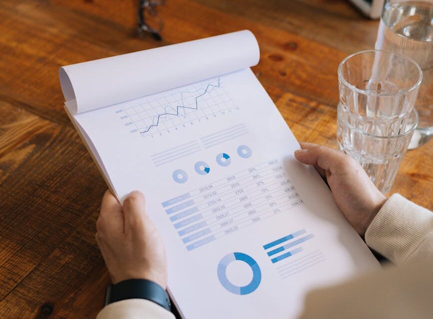 A startup founder in a modern office analyzing revenue growth charts on their laptop screen.