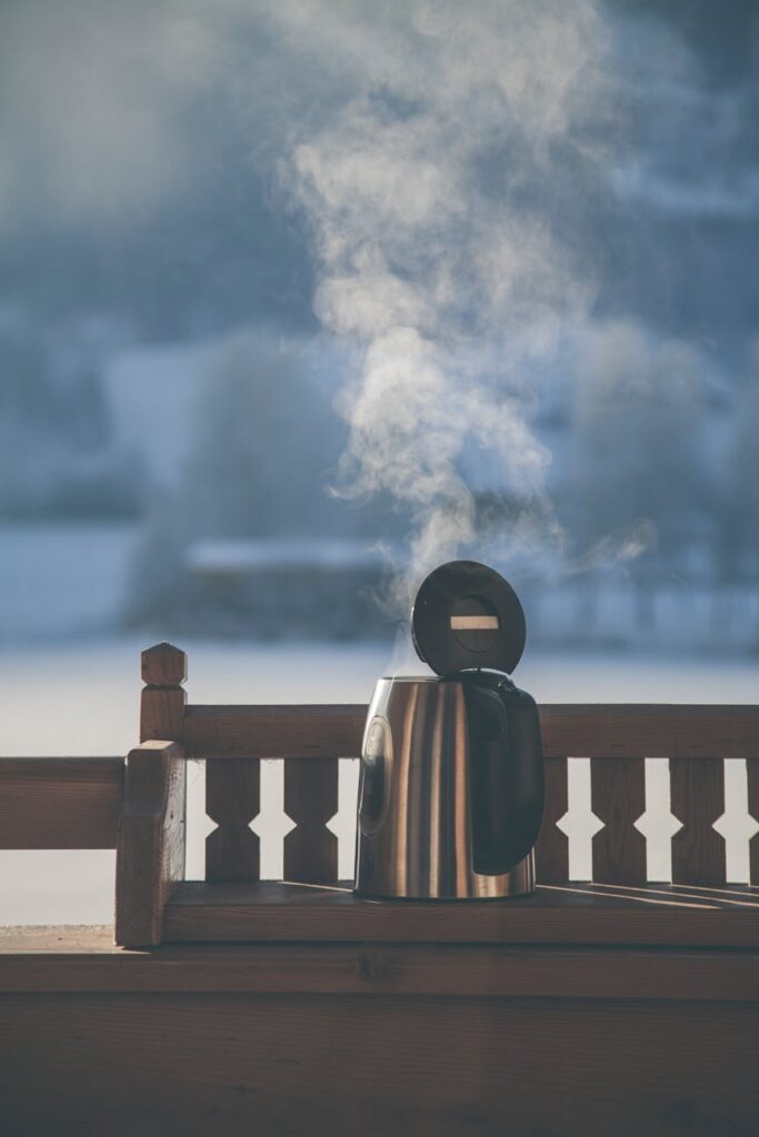 A close-up of a steaming mug of coffee resting on a wooden railing, with a blurred background of a city waking up.