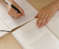 A creative professional outlining their company's 'About Us' page in a notebook.