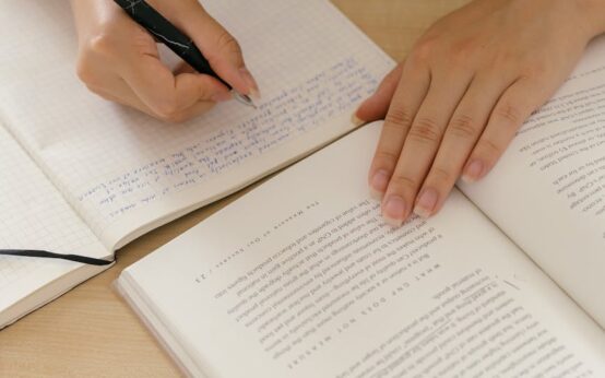 A creative professional outlining their company's 'About Us' page in a notebook.