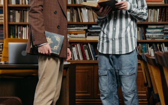 A group of focused students working together at a large table in a sunlit, modern library.